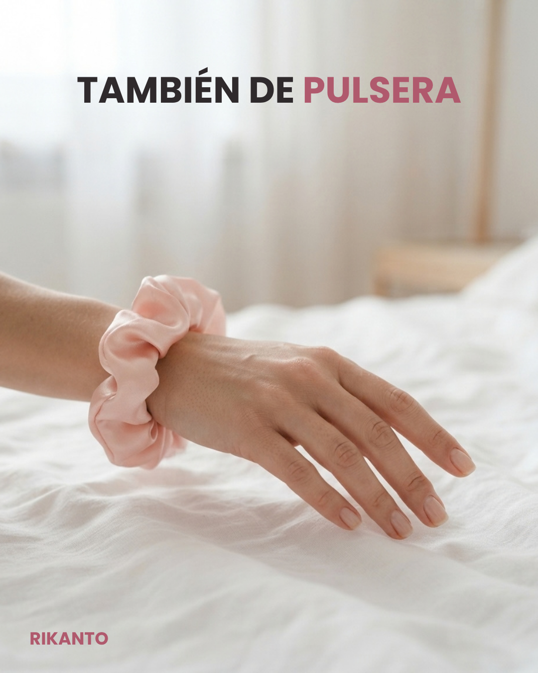 Mano con un scrunchie de satén rosa puesto en la muñeca a modo de pulsera